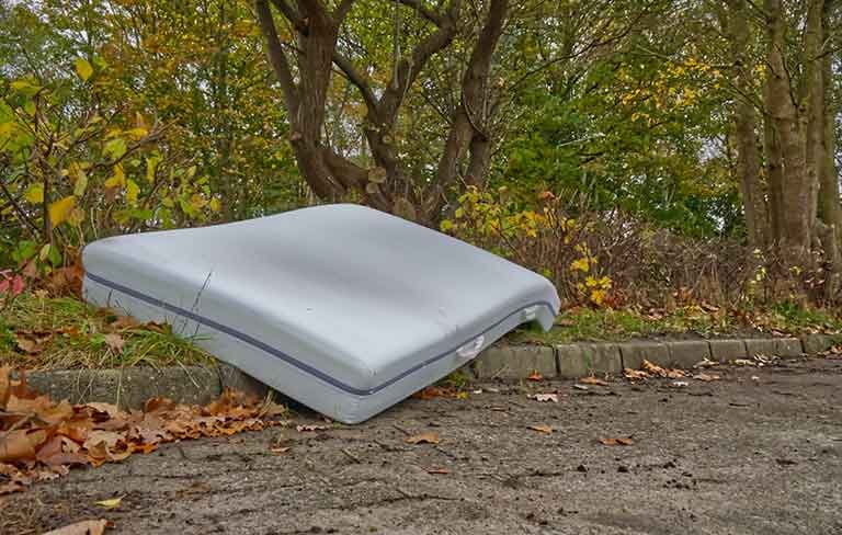 large mattress dumped in remote area