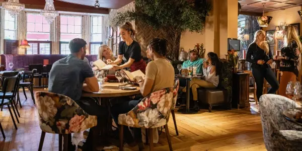 Group of people sitting down at a restaurant table representing commercial junk removal services for restaurants, event venues, and other hospitality industries