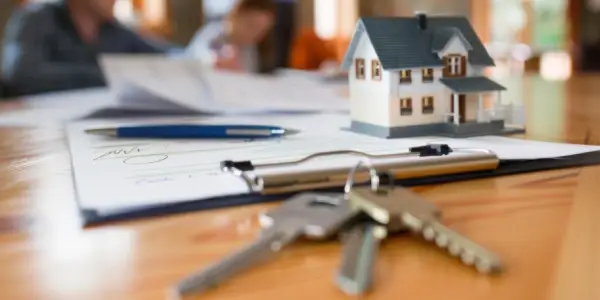 House keys on a table with a lease agreement representing Garbage Gurus serving rental and managed properties with commercial junk removal services