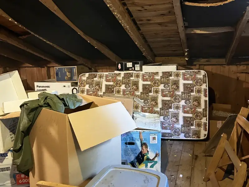 Cluttered attic space representing attic cleanout service for homes in North Central MA
