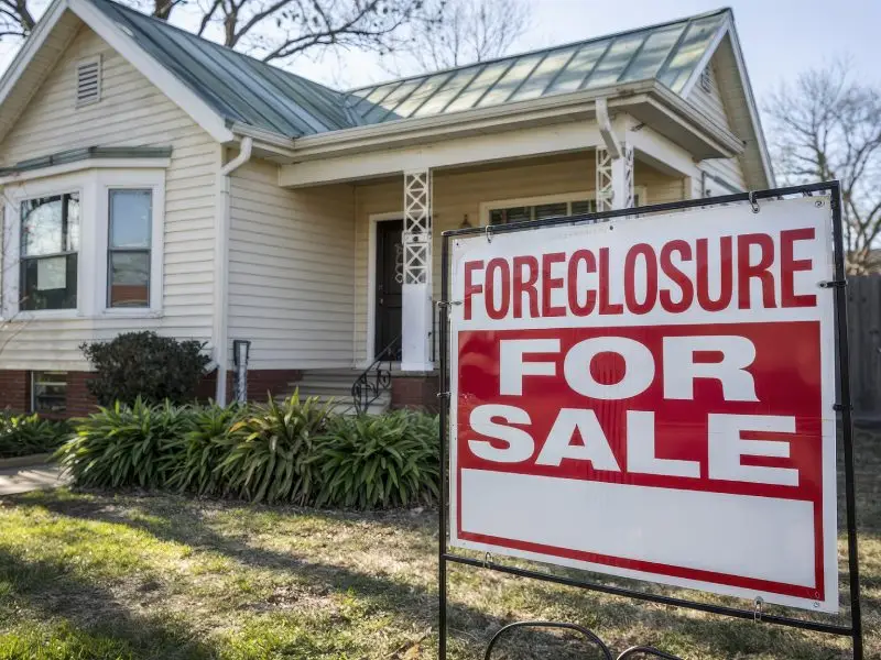 Single family house with a sign on the front yard that says Foreclosure For Sale representing Foreclosure Cleanout Service for homes in the North Central MA region