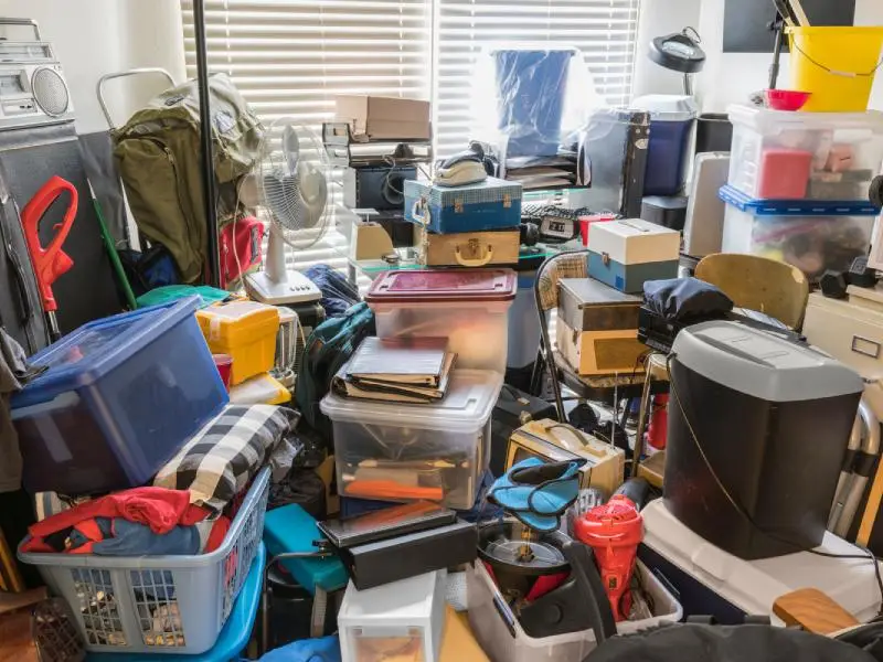 Room within a single family home filled to the ceiling with boxes, bags and plastic containers of random household junk representing hoarder cleanup service for residences in North Central MA
