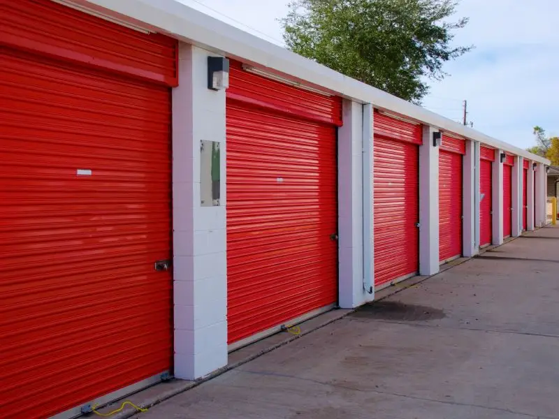 Row of closed storage units with red doors representing storage unit cleanout service for business owners and tenants in the North Central MA region