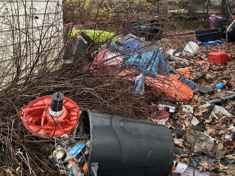 Room within a single family home filled to the ceiling with boxes, bags and plastic containers of random household junk representing hoarder cleanup service for residences in North Central MA